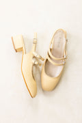 Pair of gold high-heeled shoes on a light background
