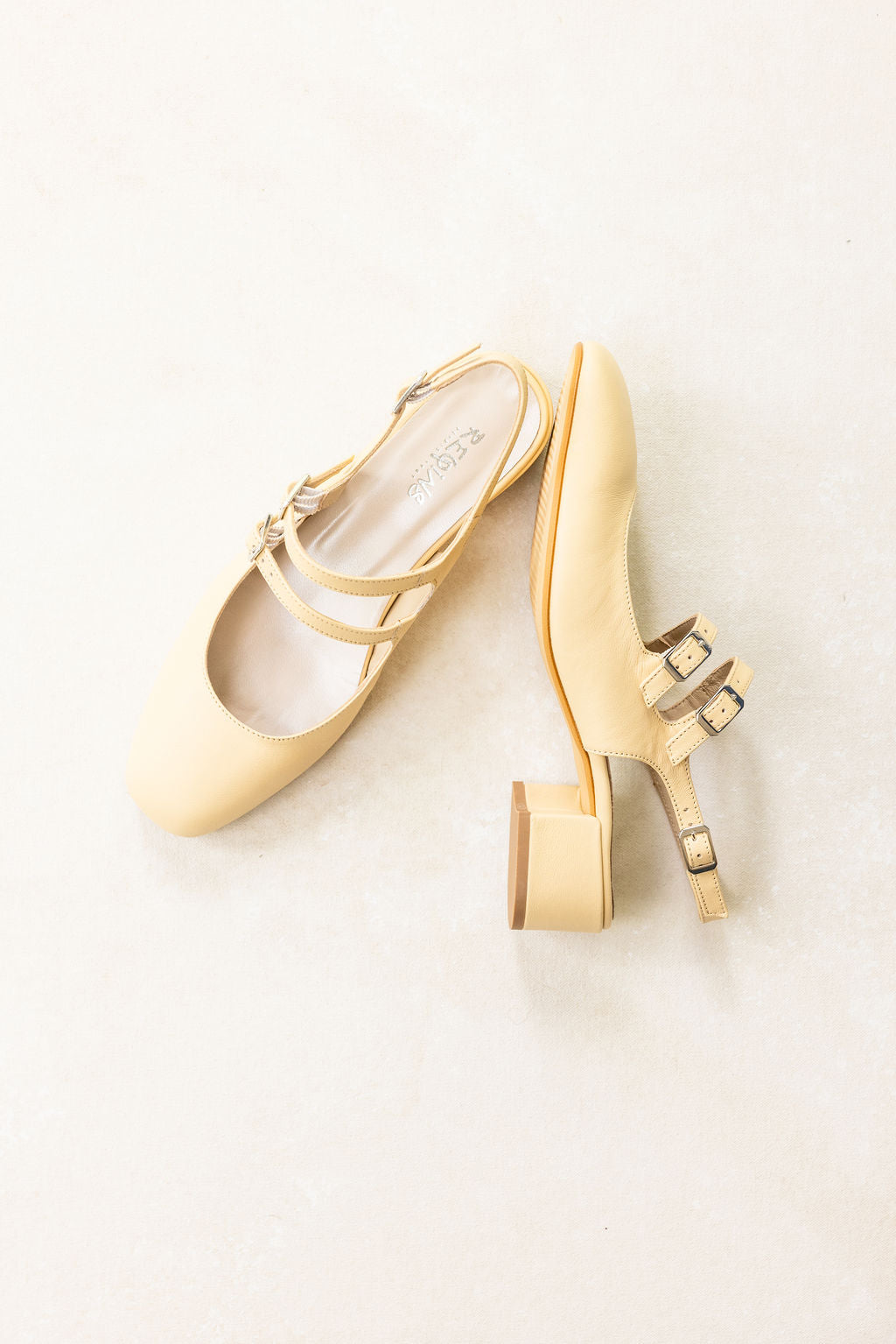 Pair of gold high-heeled shoes on a light background